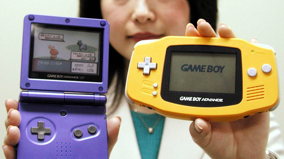 A Nintendo Co employee displays the company's new Game Boy Advance SP (L) and the current version in..